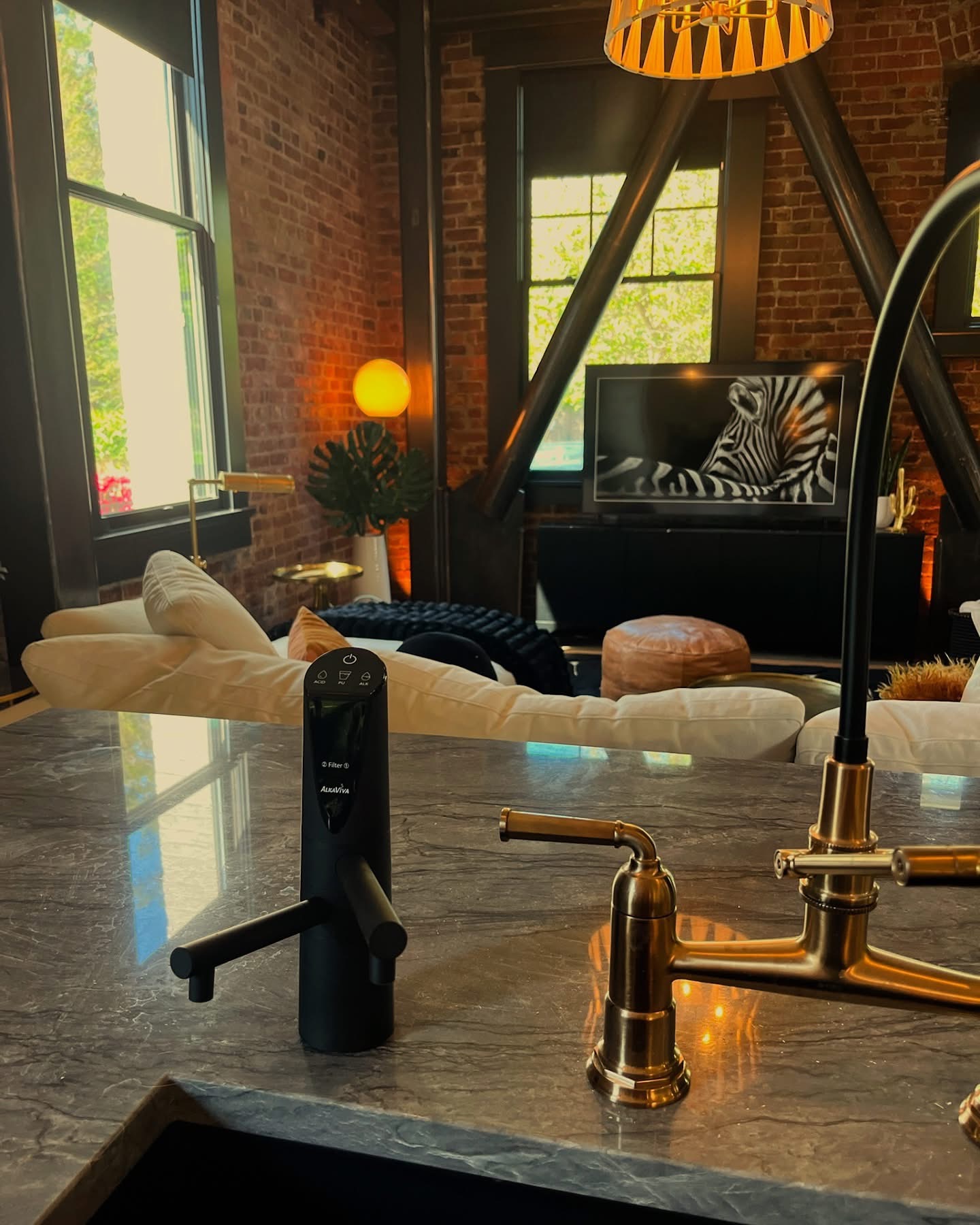Black hydrogen water dispenser installed on a stone kitchen island